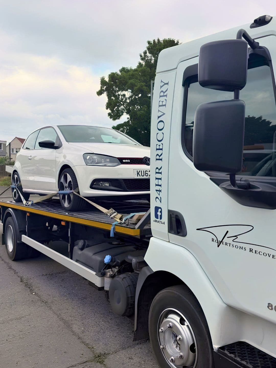 Robertsons recovery truck carrying a white Volkswagen, viewed from the front